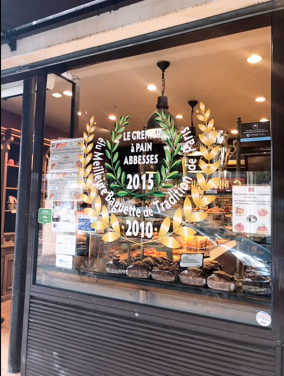 The 2010 and 2015 Baguette Competition winner stickers are prominently displayed in the window.