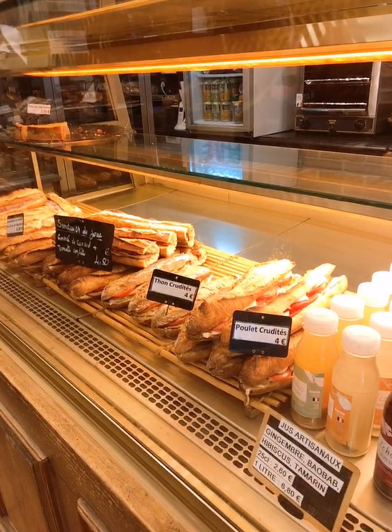 The showcase is lined with baguette sandwiches.