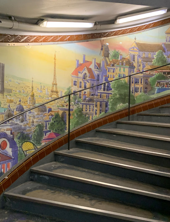 Abbesses駅の螺旋階段に描かれたパリの街並み